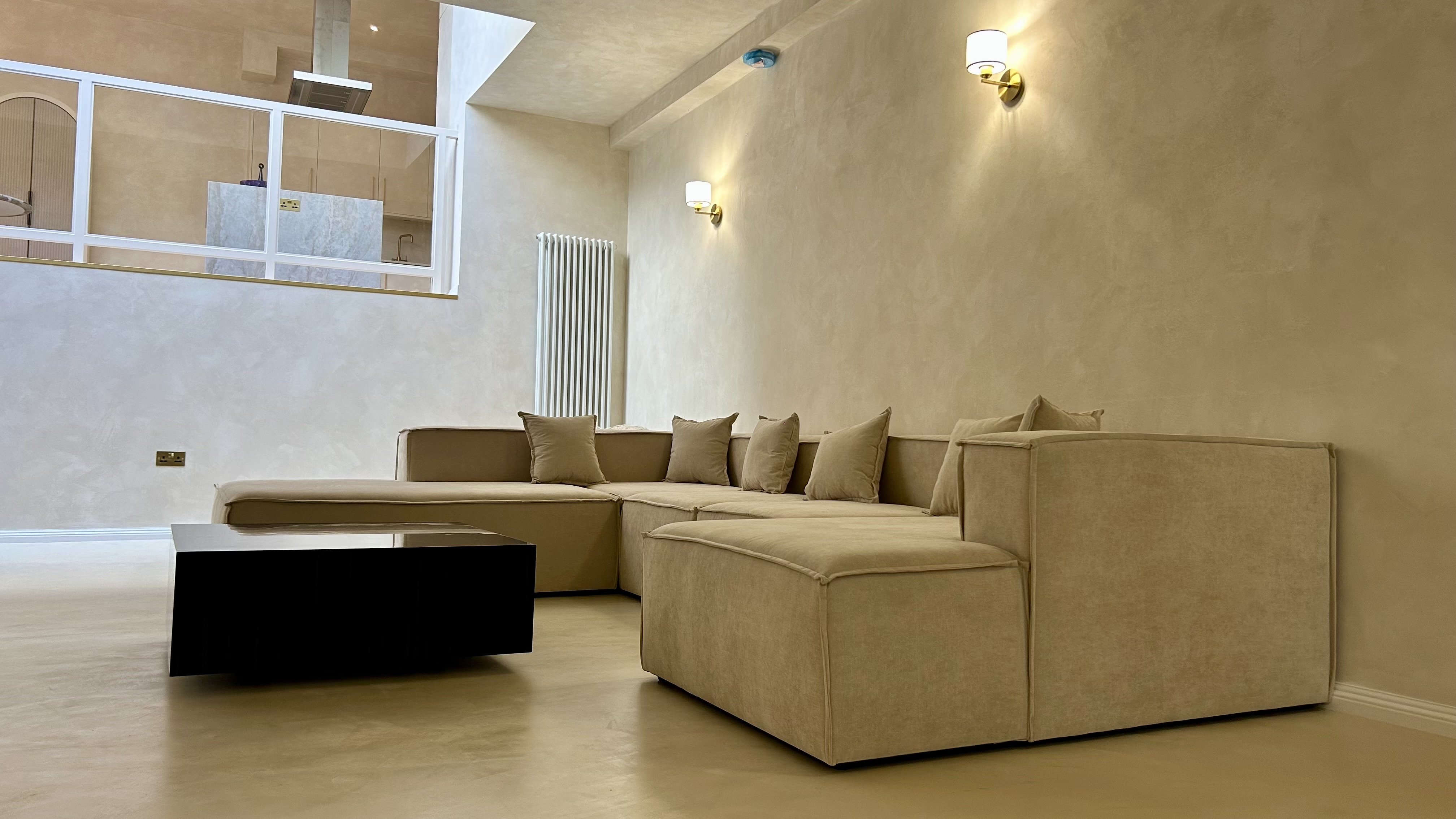 Microcement floor and Venetian plaster feature wall side by side — luxury seamless interior finishes by Atelier di Venice, London